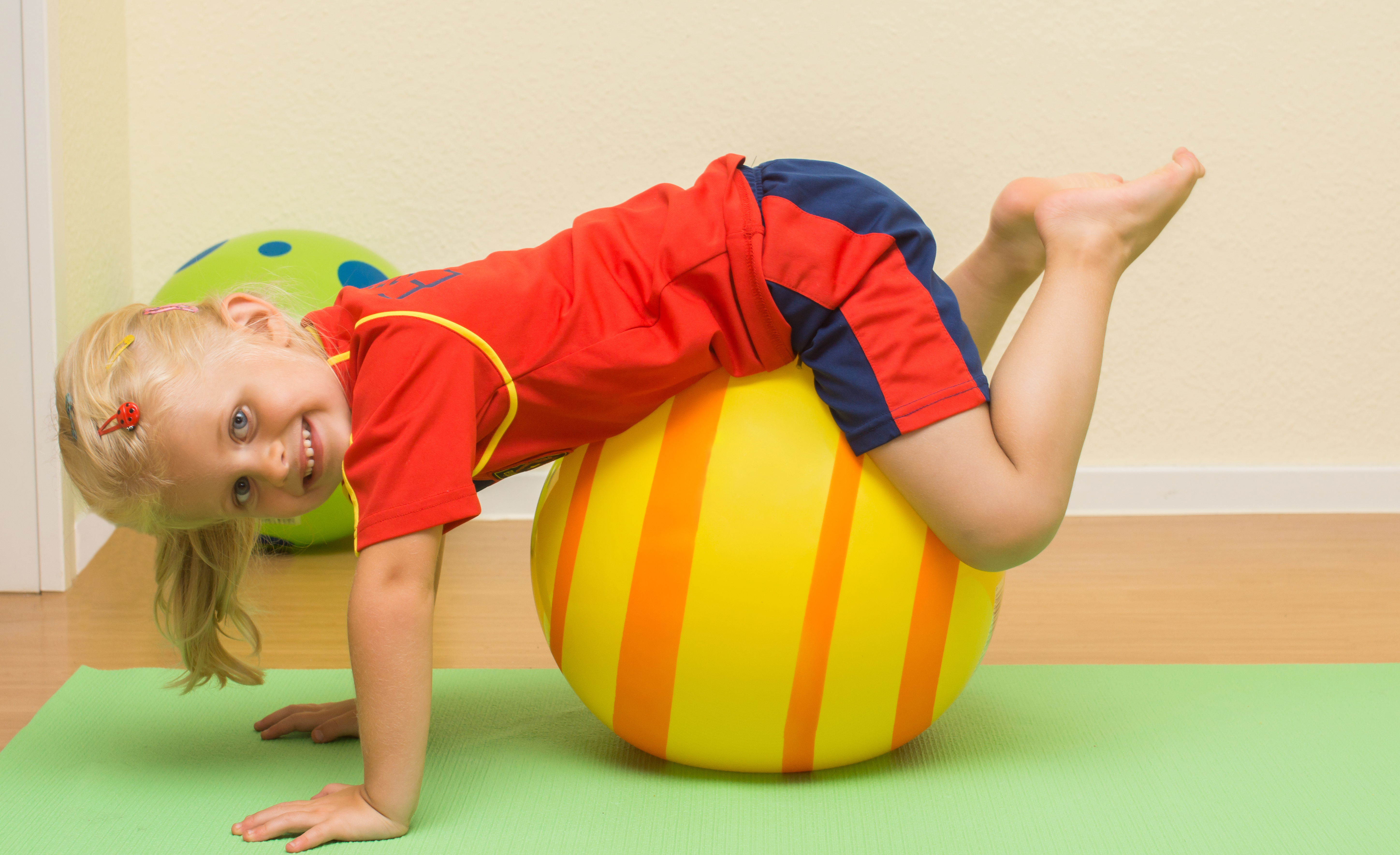 Kind bei spielerischer Therapie auf einem Gymnastikball